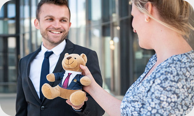 Mann übergibt Teddy an Kunden